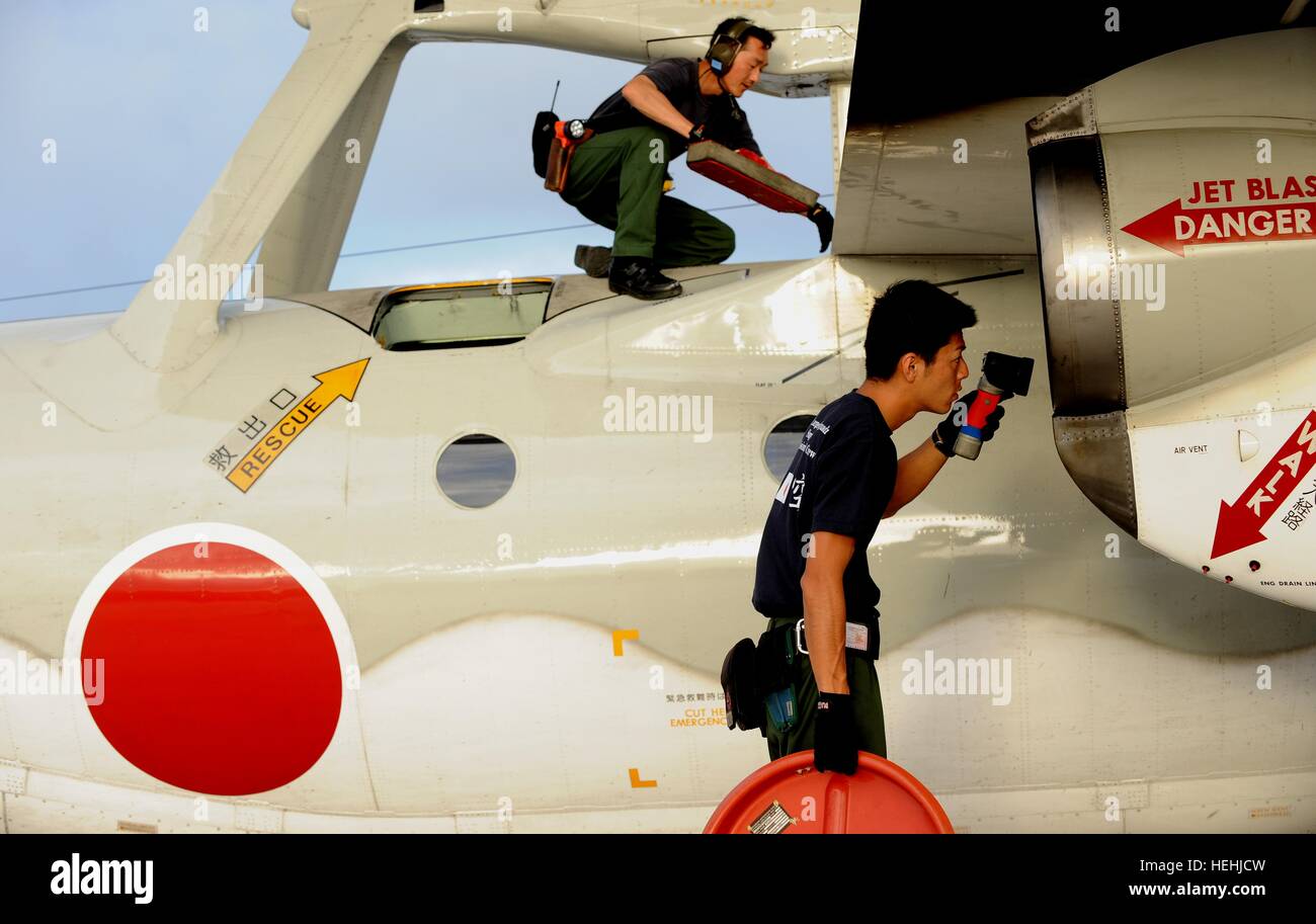 Japanese Air Self-Defense Force soldiers place intake covers over Northrop Grumman E-2C Hawkeye tactical aircraft after a local mission for exercise Cope North at the Anderson Air Force Base February 5, 2009 in Yigo, Guam. Stock Photo