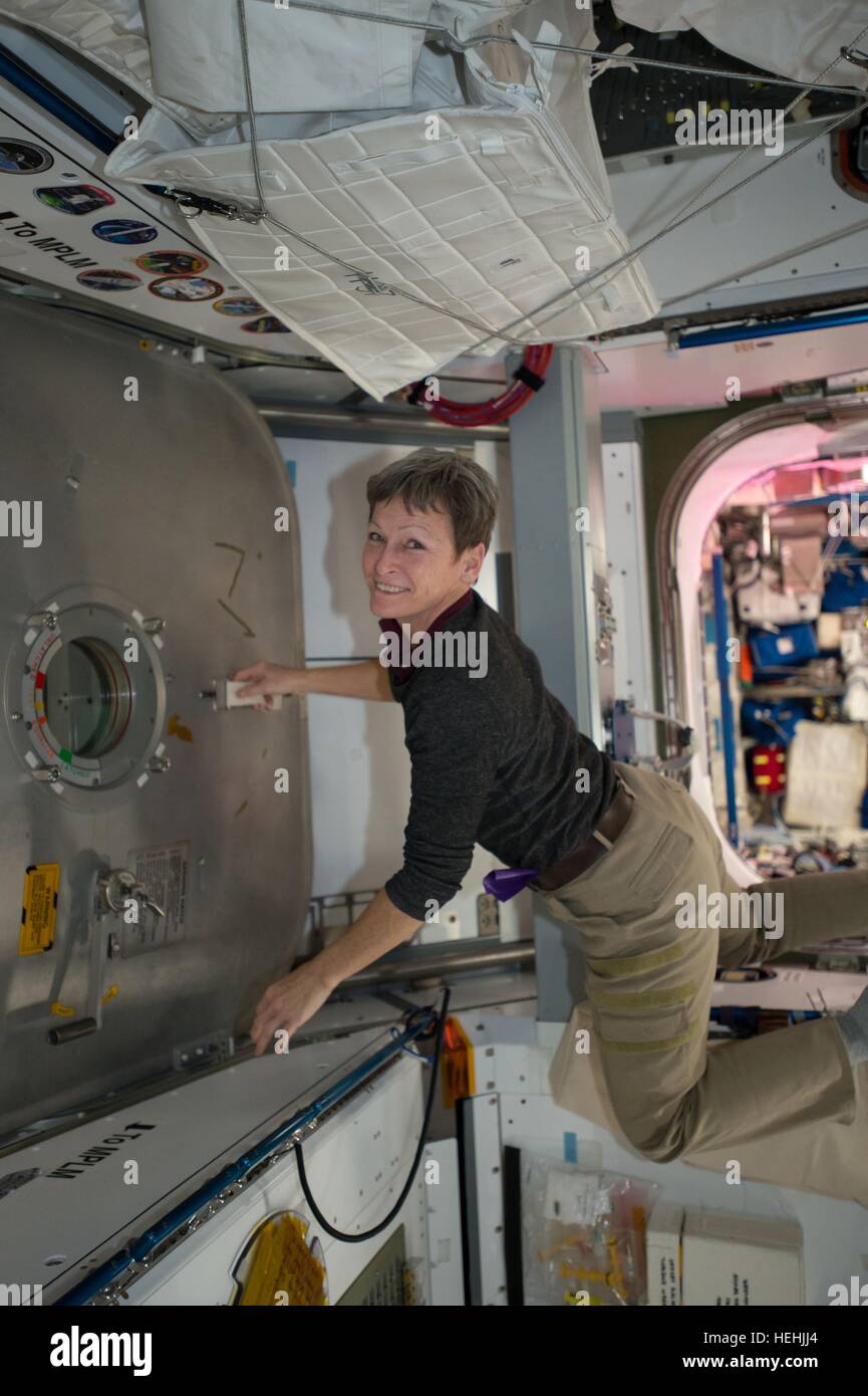 NASA Expedition 50 prime crew member astronaut Peggy Whitson works inside the International Space Station Harmony module to open the hatchway for the Japanese HTV-6 cargo craft December 13, 2016 in Earth orbit. Launched from the Tanegashima Space Center, HTV-6 arrived at the space station with more than 4.5 tons of supplies. Stock Photo