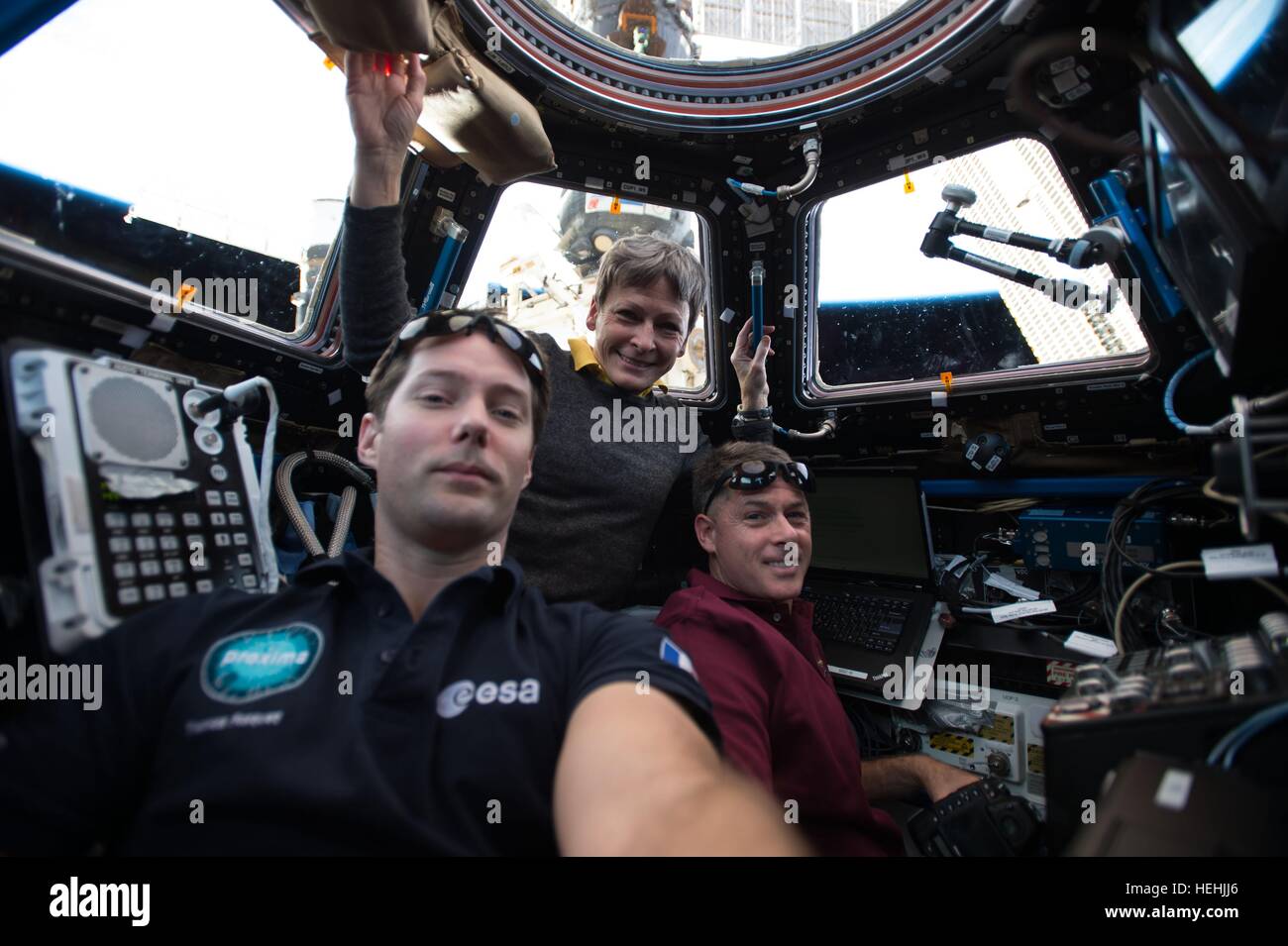 NASA Expedition 50 crew members astronauts Shane Kimbrough and Peggy Whitson of NASA and French astronaut Thomas Pesquet of the European Space Agency undergo robotics training inside the International Space Station Cupola December 6, 2016 in Earth orbit. Stock Photo
