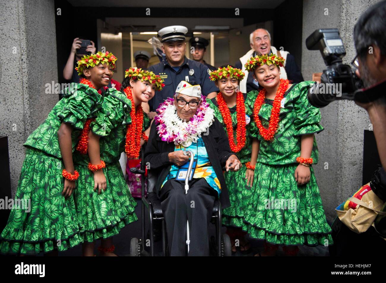 Oldest surviving World War II Pearl Harbor U.S. veteran, 104-year-old Ray Chavez, is greeted by local Hawaiian children with floral leis after arriving at the Honolulu International Airport to participate in commemoration events to honoring the 75th anniversary of the Pearl Harbor attacks December 3, 2016 in Honolulu, Hawaii. Stock Photo