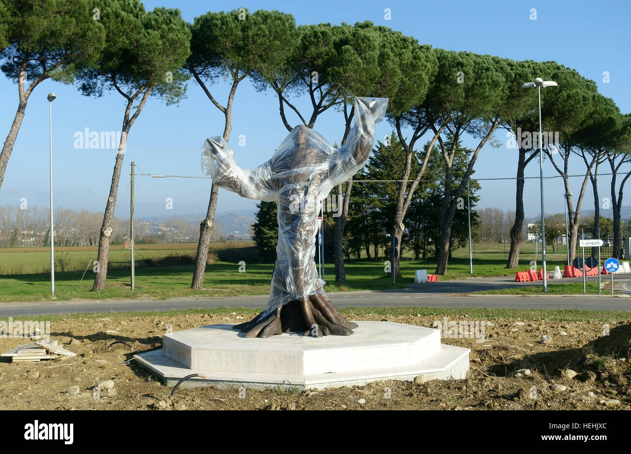 A bronze statue is covered in plastic sheeting outside Perugia airport Stock Photo