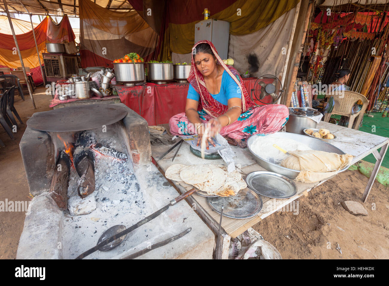 Woman making, cooking and selling chapatis or traditional Indian bread in a street stall, Pushkar, India Stock Photo
