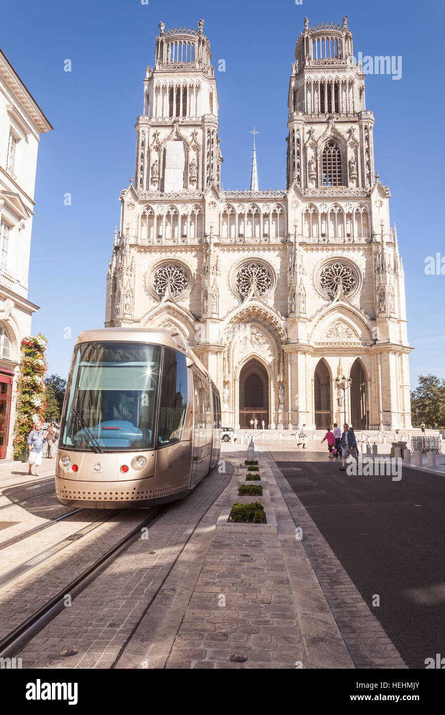 A tram passes The cathedrale Sainte Croix d'Orleans or the cathedral of Orleans in France. Stock Photo