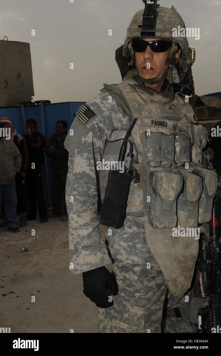 Cpl. Chris Paukei of Cyril, Okla., from 3rd Brigade Combat Team, 4th Infantry Division, pulls security while the Sons of Iraq are set to receive their pay for the second time from the Iraqi government on Dec. 22, 2008 in Baghdad, Iraq. Sons of Iraq receive second payment 144415 Stock Photo