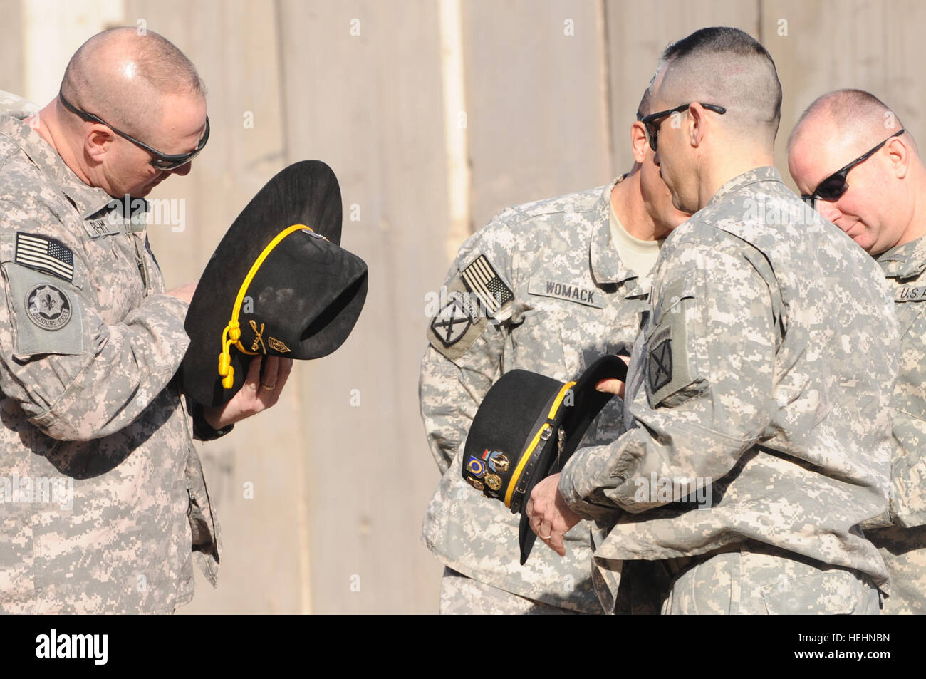U.S. Army 1st Sgt. Wesley Rehm (left), Command Sgt. Major Steven Womack, Sgt. Major Ronald Semerena, and Maj. Robert Ballagh (right) all of 4th Brigade Combat Team, 10th Mountain Division, inspect their cavalry campaign hats during a ceremony to mark the transition of authority from the 3rd Squadron, 89th Cavalry, 4th Brigade Combat Team, 10th Mountain Division, to the 573rd Cavalry, 3rd Brigade Combat Team, 82nd Airborne Division on Forward Operating Base Loyalty, eastern Baghdad, Iraq, on Dec. 30, 2008. Transfer of Authority at Forward Operating Base Loyalty 140533 Stock Photo