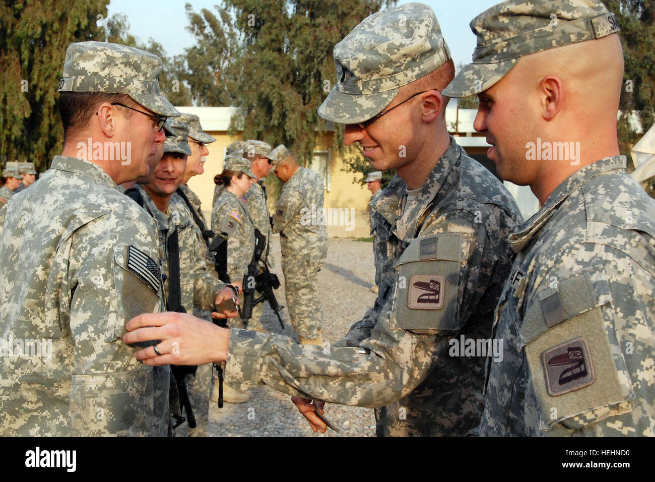 First Lt. Sean Taborne from Port Orchard, Wash., the Personal Security Detail platoon commander with Alpha Company, 181st Brigade Support battalion, 81st Brigade Combat Team, Washington Army National Guard, awards combat patches to his platoon Dec. 30, 2008 at Joint Base Balad, Iraq. In a tradition dating back to WWII, combat patches depicting the unit they serve with during wartime are placed on each Soldier's right sleeve. The 106 members of A Co.,181st BSB provide security for Iraqi businesses on base and the hospital, escort local nationals working on base and provide Personal Security Det Stock Photo