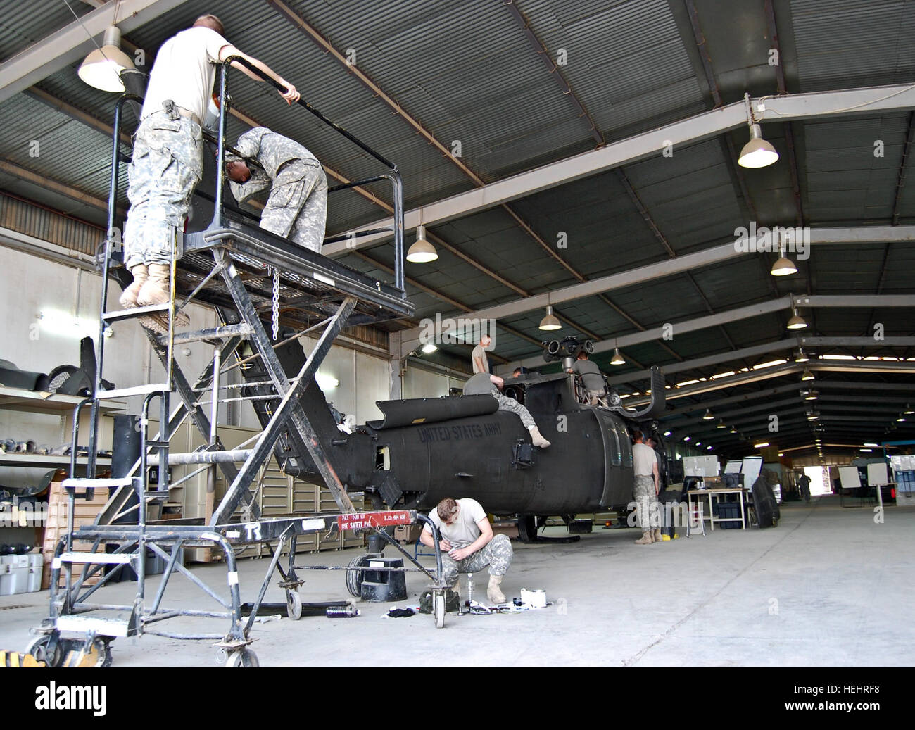 Soldiers from Company B, 404th Aviation Support Battalion, Combat Aviation Brigade, 4th Infantry Division, Multi-National Division - Baghdad, perform phase maintenance on a UH-60 Blackhawk helicopter at Camp Taji March 5. Once an aircraft is scheduled for phase maintenance it is brought in to the company's service bay, it is stripped down, critical parts are inspected for wear and tear and worn or broken parts are replaced or repaired. Phase maintenance professionals keep helicopters flying high 168427 Stock Photo