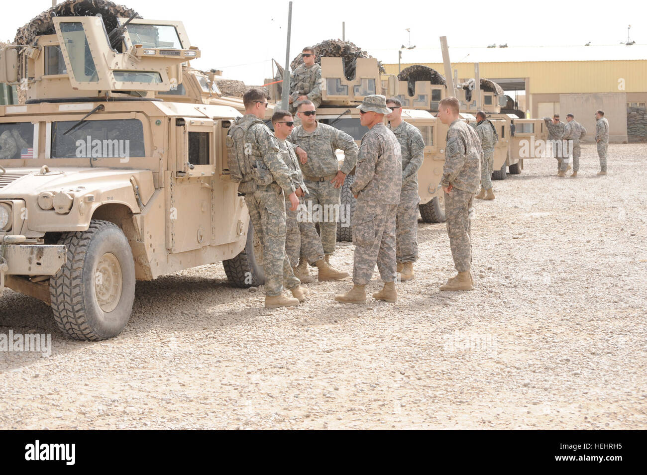 U.S. Soldiers of Bravo Company, 2nd Battalion, 505th Parachute Infantry Regiment, 3rd Brigade Combat Team, 82nd Airborne Division, wait near their vehicles at Joint Security Station Suj, in eastern Baghdad, Iraq, on March 8. The Soldiers are waiting to depart on a joint operation with Iraqi national police to distribute supplies to local schools. Soldiers, Iraqi national policemen distribute school supplies in Baghdad 157183 Stock Photo