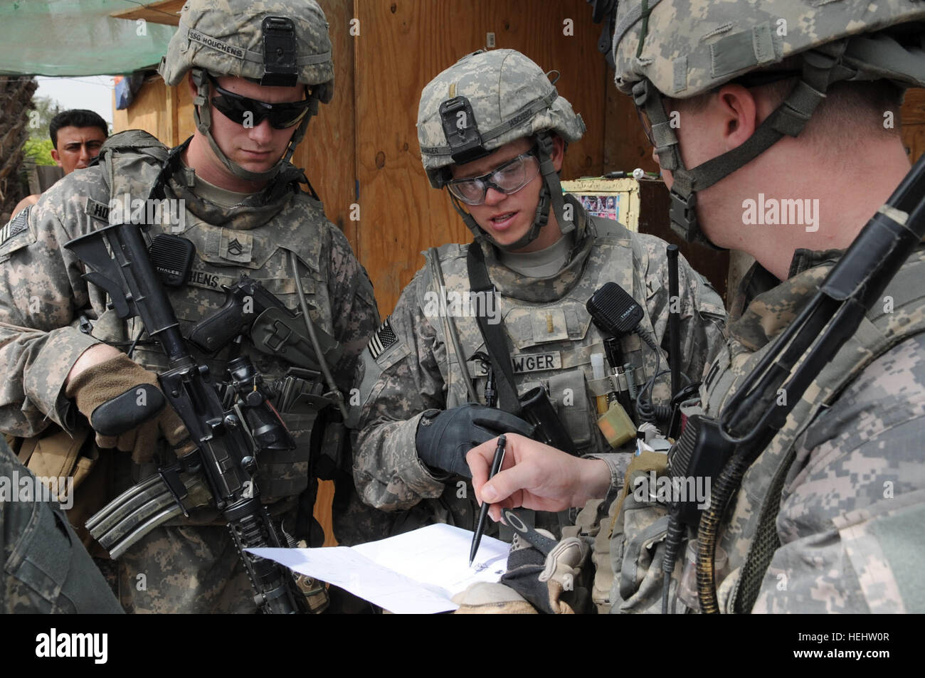 U.S. Army paratroopers and officers discuss checkpoint operations near ...
