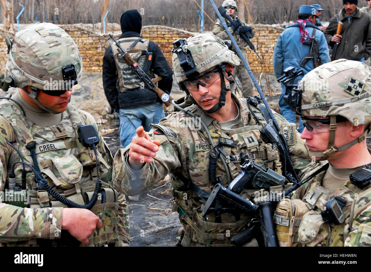 Capt. Joe Pazcoguin, commander of Company B, 1st Battalion, 67th Armor Regiment, 2nd Brigade Combat Team, 4th Infantry Division, talks with 1st Lt. Austin Cattle of Company B and 1st Lt. Mitchell Creel of the 530th Engineer Company during a clearance operation in western Kandahar City, Feb. 1.  The joint clearance with the Afghan Uniformed Police of Police Substation 8 yielded three mortar rounds, seven rocket-propelled grenades and one anti-personnel mine. Pazcoguin is a native of Altoona, Pa. while Cattle and Creel hail from Everett, Wash. and Monroe City, Mo. respectively. Flickr - The U.S. Stock Photo