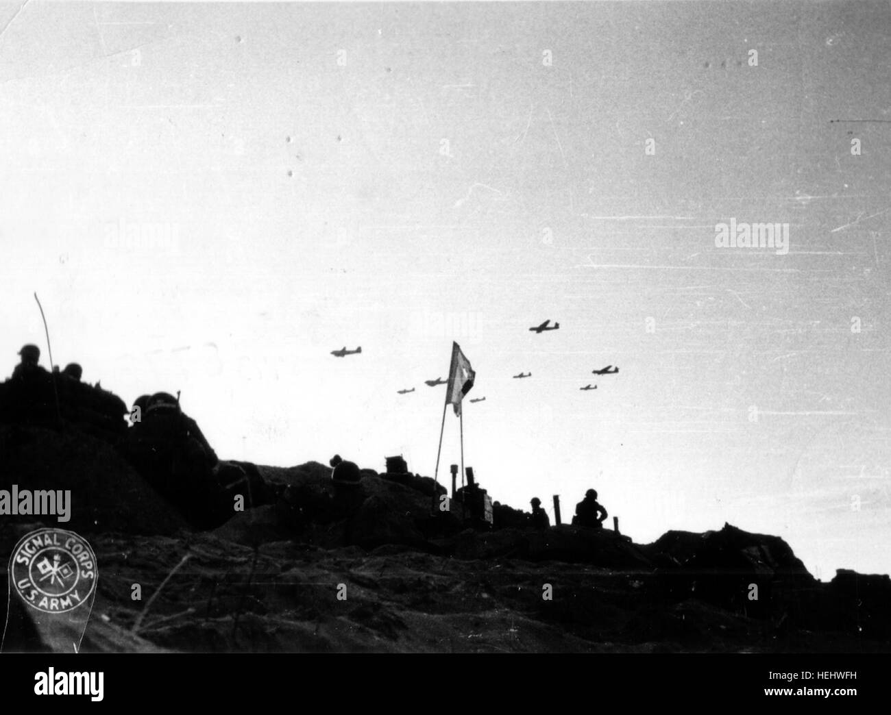 Des planeurs Horsa remorqués par des C-47 survolent Utah Beach par-dessus laquelle furent amenés les renforts pour la 82nd Airborne par planeurs. Ceci permet de dater la photographie au 7 juin 1944 (date de ces missions) pour LZ 'W' : Les Forges  -Galveston (arrivée sur LZ à 07h00 le 7 juin de 18 Horsa) -et Hackensack (arrivée sur LZ à 09h00 le 7 juin de 25 Horsa) Au premier plan, on devine,  trois MP (Military Police) reconnaissables à leur casque avec la bande blanche ou jaune, dont un sous-officier (trait horizontal blanc à l'arrière du casque). http://www.flickr.com/photos/mlq/3041272228/  Stock Photo