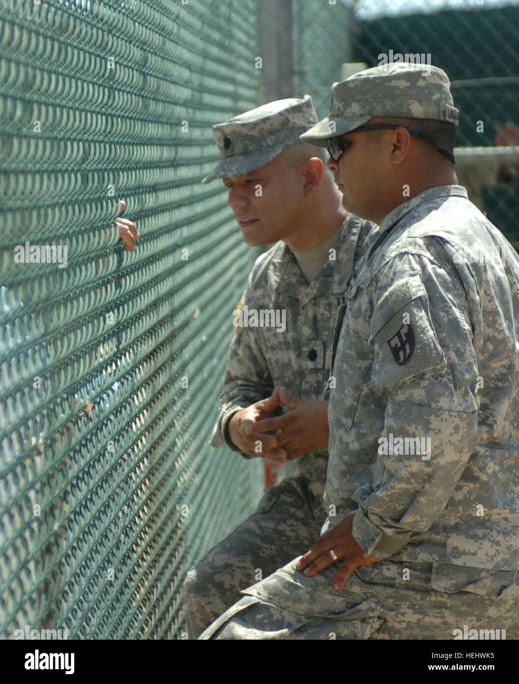 Army Lt. Col. Miguel Mendez, detainee programs director at Joint Task Force Guantanamo, listens to a detainee who requested particular books from the library at Camp 4, April 23. JTF Guantanamo conducts safe, humane, legal and transparent care and custody of detainees, including those convicted by military commission and those ordered released. The JTF conducts intelligence collection, analysis and dissemination for the protection of detainees and personnel working in JTF Guantanamo facilities and in support of the Global War on Terror. JTF Guantanamo provides support to the Office of Military Stock Photo