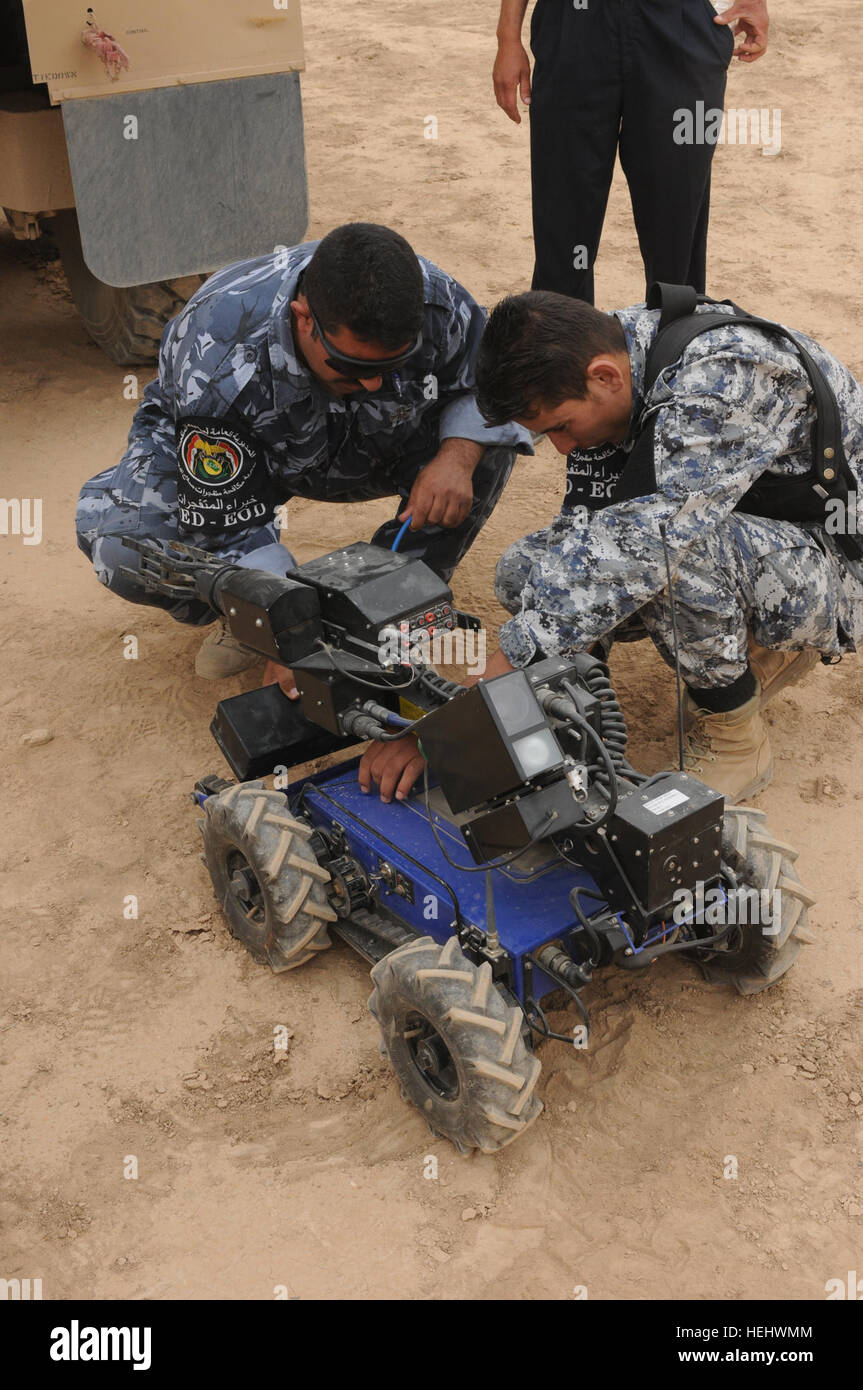 Members of the Iraqi police counter explosive team replace the dead battery on the Explosive Ordnance remote control robot during a training exercise on Contingency Operating Base Speicher, in Tikrit, Iraq, on April 25. Iraqi Explosive Ordnance Disposal Training in Tikrit, Iraq 169163 Stock Photo