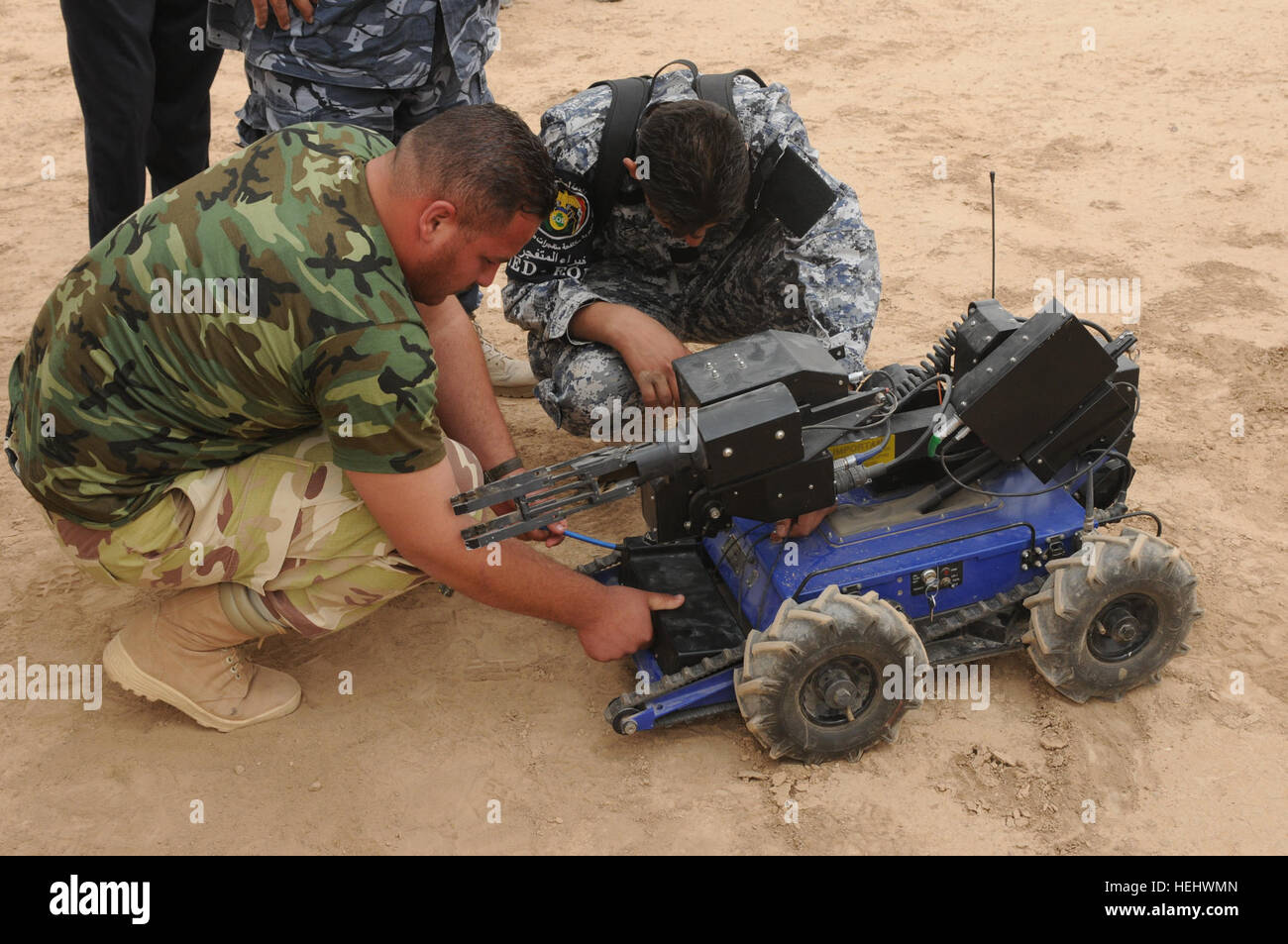 Members of the Iraqi police counter explosive team replace the dead battery on the Explosive Ordnance remote control robot during a training exercise on Contingency Operating Base Speicher, in Tikrit, Iraq, on April 25. Iraqi Explosive Ordnance Disposal Training in Tikrit, Iraq 169164 Stock Photo