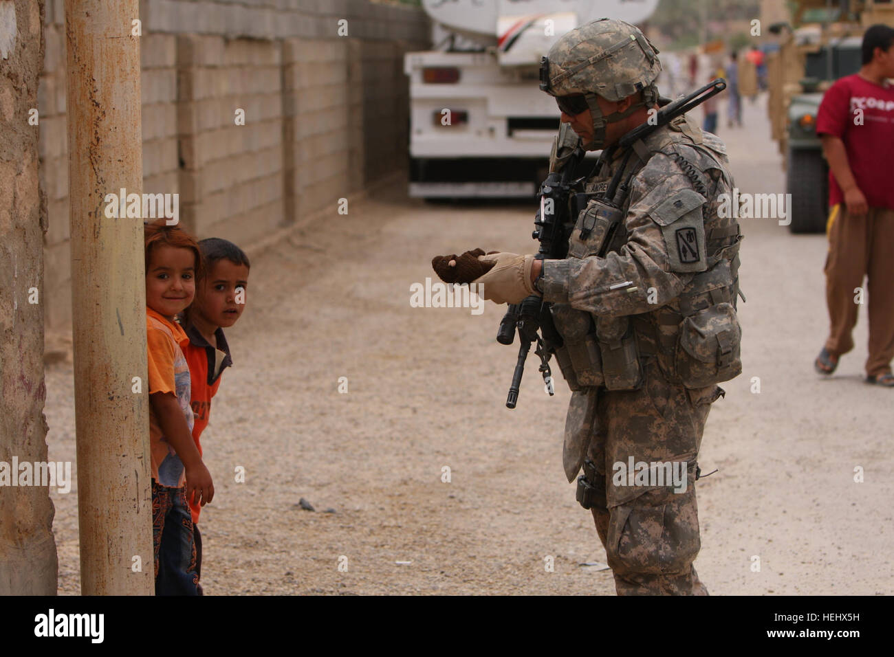 Staff Sgt. David Andrews of Duncan, Okla., a member of 1st Battalion 158th Field Artillery, 45th Fires Brigade, Oklahoma Army National Guard, stops to visit with some young children during a foot patrol through a village outside of Camp Ramadi, Iraq, May 10, 2009. Members of the 1-158th FA were deployed last fall to help provide security for the camp and conduct patrols in order to help maintain the safety of Camp Ramadi and the outlying villages. Camp Ramadi patrols 172880 Stock Photo