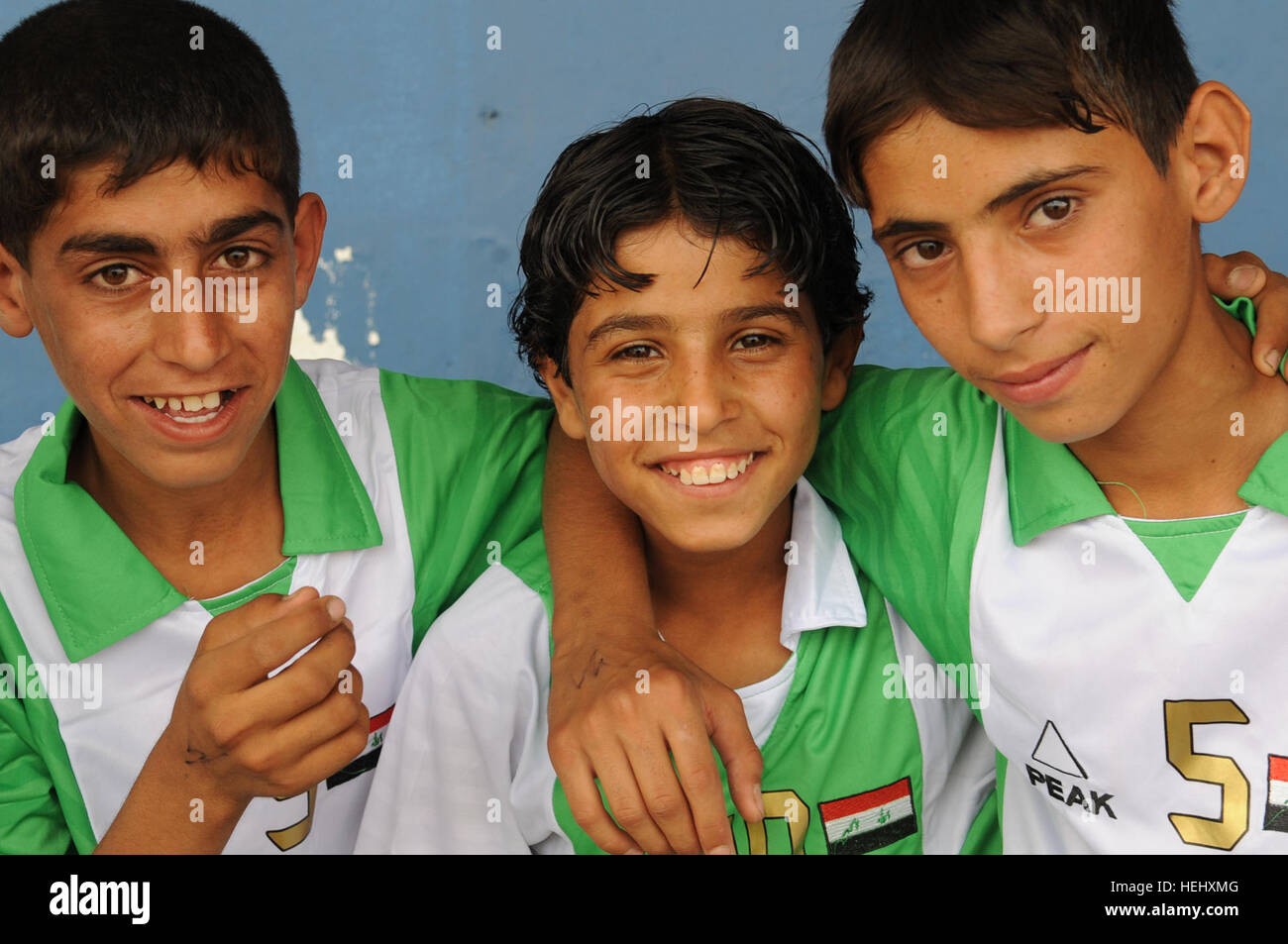 Iraqi boys smile for the camera outside Sha'ab stadium, in eastern Baghdad, Iraq, on May 22