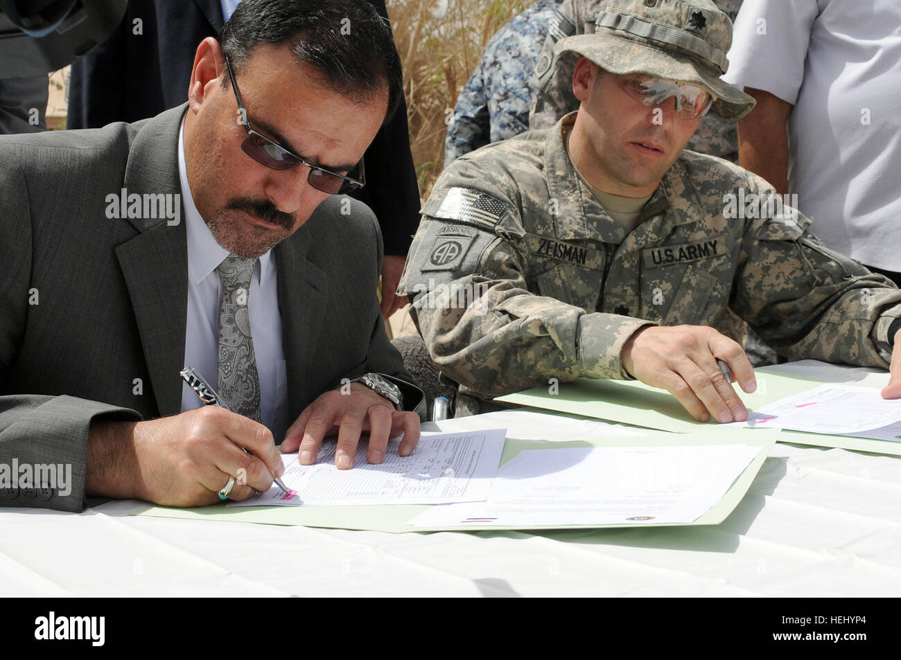 A representative of the Iraqi Ministry of the Interior, and U.S. Army Lt. Col. Louis Zeisman from Fayetteville, N.C., commander of 2nd Battalion, 505th Parachute Infantry Regiment, 3rd Brigade Combat Team, 82nd Airborne Division, prepare to sign paperwork officially transferring control of Joint Security Station Oubaidy in eastern Baghdad, Iraq, on June 20. Control of the joint security station is being transferred from the U.S. Army, 2nd Battalion, 505th Infantry Regiment, 3rd Brigade Combat Team, 82nd Airborne Division to the Iraqi national police. Transfer of authority ceremony for Joint Se Stock Photo