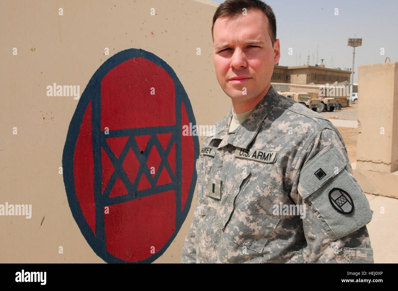 First Lt. Scott Sharkey of the Colorado Army National Guard's 86th Military Intelligence Company stands in front of a painted 30th Heavy Brigade Combat Team patch at Forward Operating Base Falcon July 25. The patch, the combat version of which can be seen on Sharkey's left sleeve, dates back to the founding of the 30th Infantry Division in 1917. Sharkey's grandfather, Allen, was attached to the division in World War II and earned a Bronze Star with 'V' device for valor while with the unit.   Scott wasn't aware that his grandfather had served with 'Old Hickory,' as the then-division and current Stock Photo