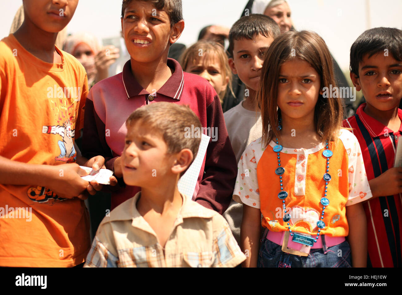 Local children wait patiently for their names to be called during a humanitarian-aid mission supported by U.S. Soldiers assigned to Golf Battery, 82nd Field Artillery Regiment, 3rd Battalion, 2nd Brigade Combat Team, 1st Cavalry Division, in Adalla, Iraq, Aug. 9. Operation Iraqi Freedom 193856 Stock Photo