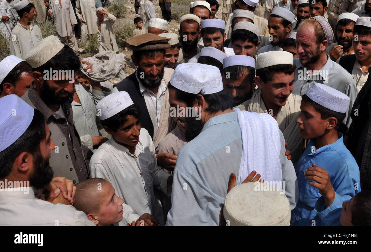 Local villagers welcome back a released detainee to the Achin District in the Nanghar province Afghanistan, Aug. 16. The combined team delivered humanitarian aid supplies, medical care and released a detainee from Bagram Air Field back to his family in the Bagh Village. Afghan locals greet released detainee, coalition forces 215091 Stock Photo