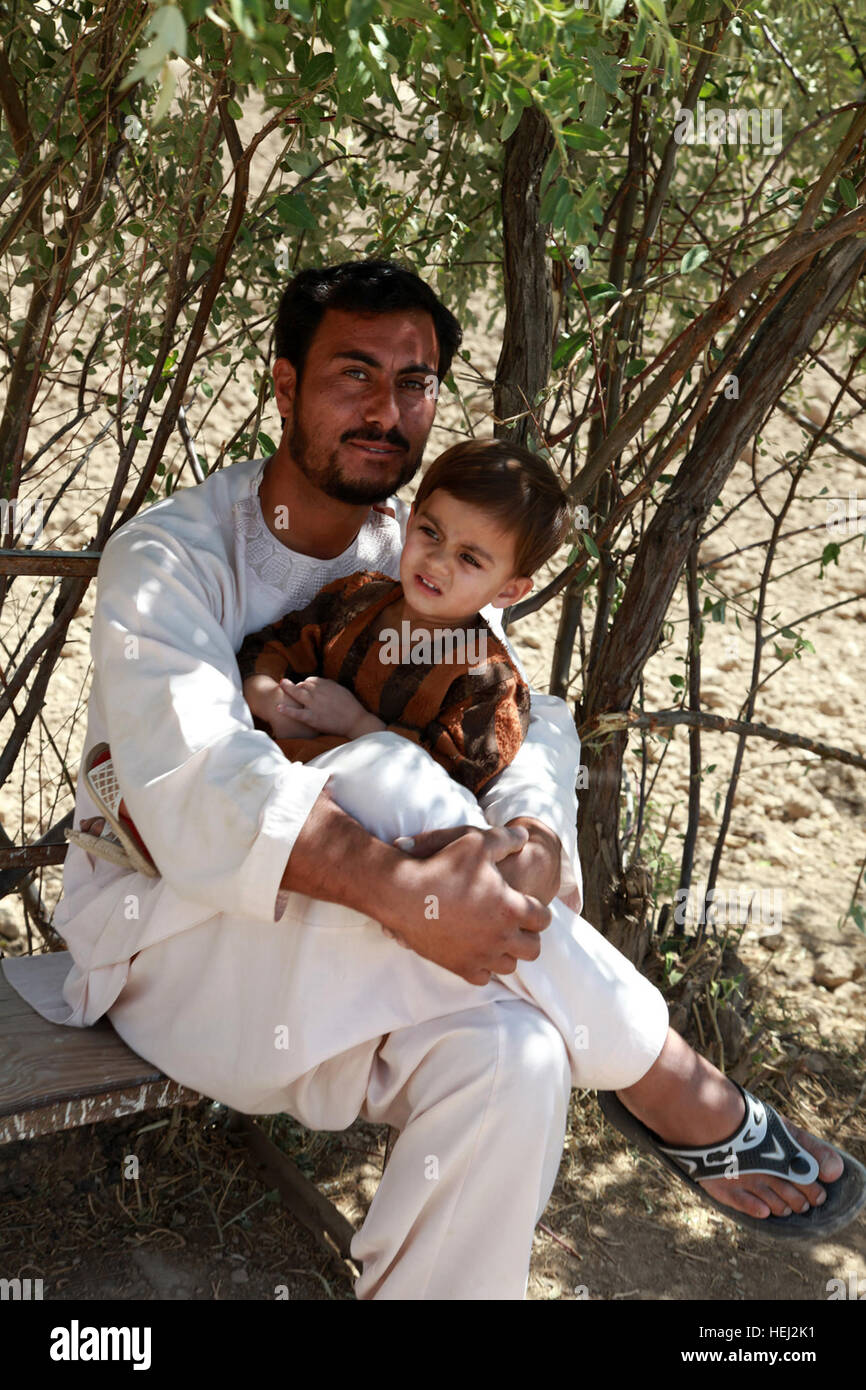 An Afghan father holds his son during mid-day in Logar province, Afghanistan, Sept. 3. U.S., Afghan forces deliver school supplies in Logar province 202305 Stock Photo
