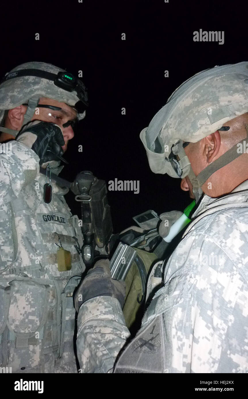 Staff Sgt. Christopher Ayala, a distribution platoon sergeant from El Paso, Texas, examines equipment during pre-combat checks and inspection on Spc. Christian Gonzalez, a medic from El Paso, Texas, prior to mounting vehicles and departing for a combat logistics patrol to Joint Security Station Al Wahab on the Iran-Iraq border. The Soldiers are attached to 2nd Squardron, 13th Cavalry Regiment deployed from Fort Bliss, Texas. Delta Forward Support Companie sustains the Force across Maysan 203951 Stock Photo