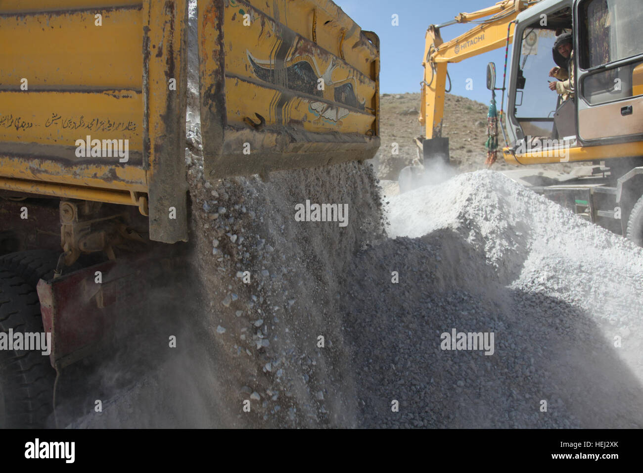 Afghan construction workers work on a road construction project in