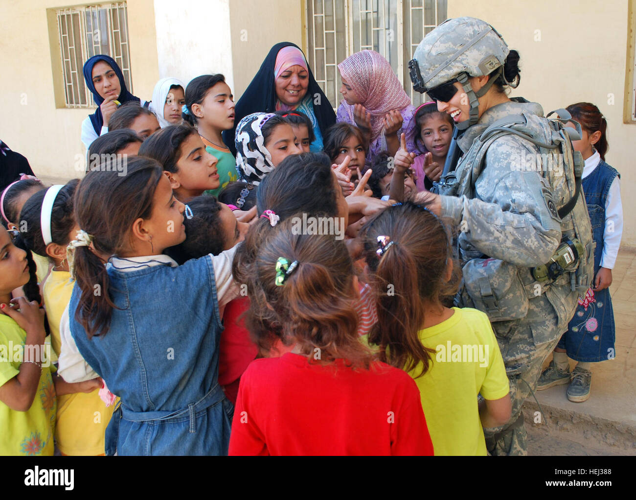 Spc. Ikram Mansori, of San Francisco, Calif., greets a group of Iraqi girls after giving them toys during a combined humanitarian assistance mission at the Gulgamesh Elementary School, Sept. 13, in the town of Salman Pak, Iraq, located 30 miles southeast of Baghdad. Iraqi soldiers and Paratroopers assigned to Company B, 1st Battalion, 505th Parachute Infantry Regiment, 3rd Brigade Combat Team, 82nd Airborne Division, Multi-National Division-Baghdad teamed up to provided much-needed supplies such as backpacks, pencils, personal hygiene products and books to the school's children. Mansori, who s Stock Photo