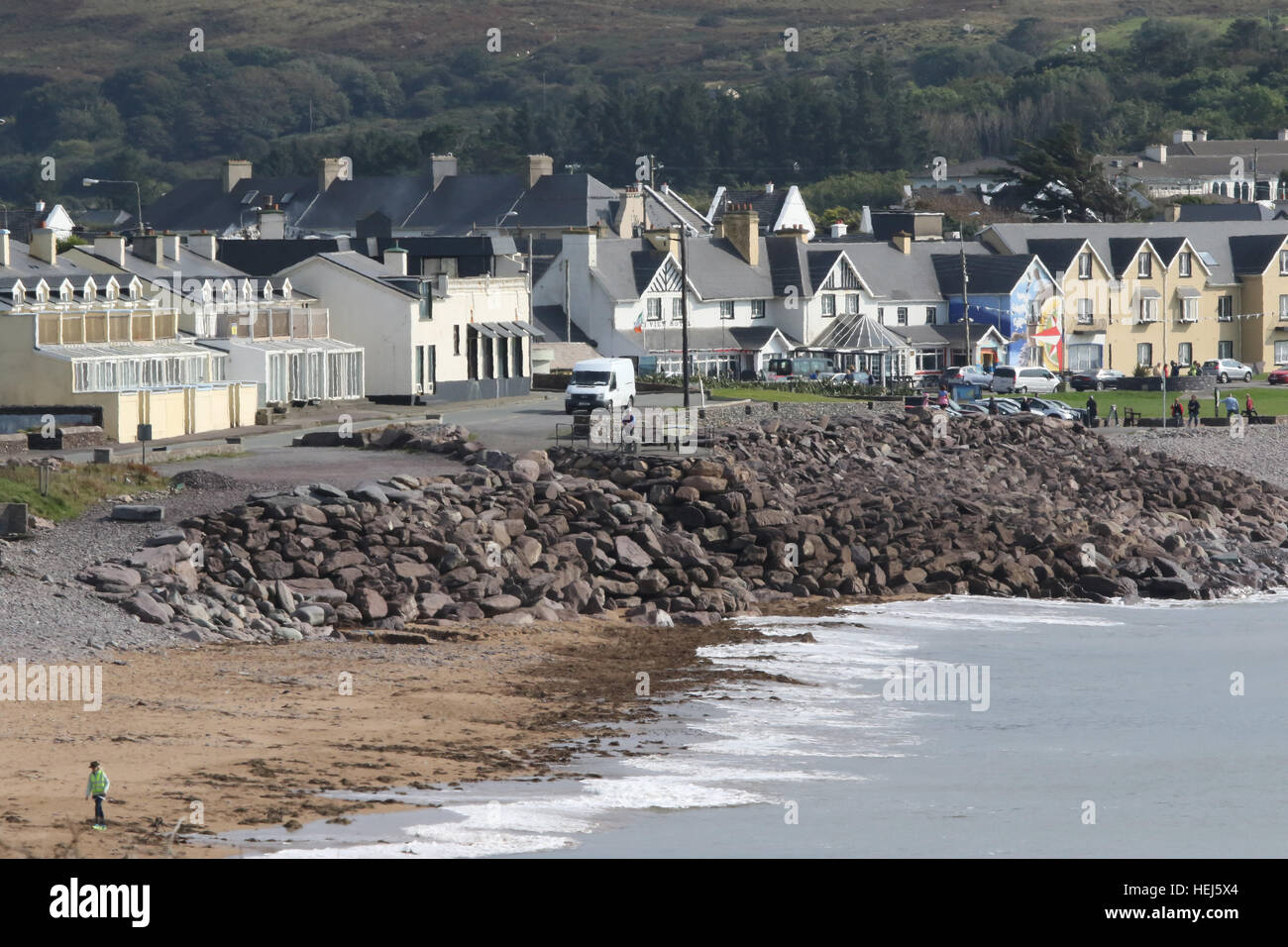 Costal road on the Wild Atlantic Way in Ireland running through the village of Waterville with its colourful seafront houses and stoney beach.. Stock Photo