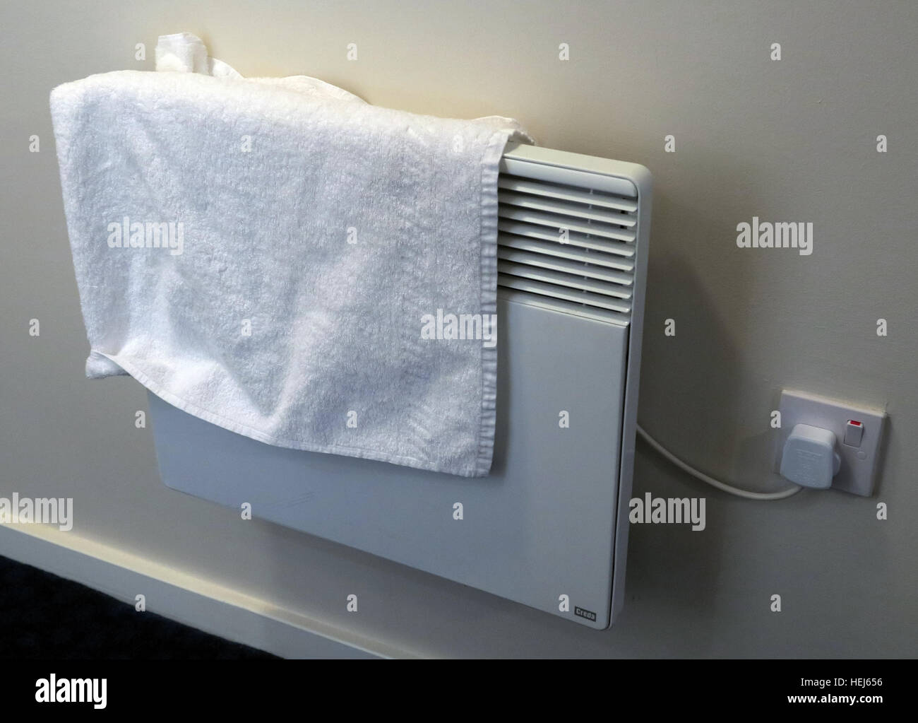 Drying towels or clothes on electric convection heaters,danger of fire Stock Photo
