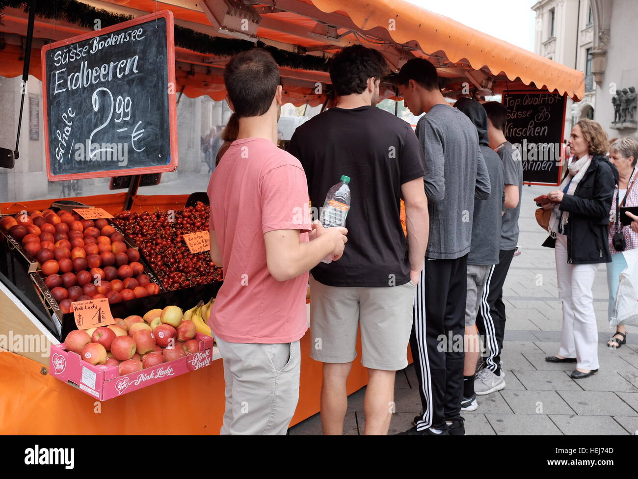 People purchasing fresh fruit at a summer outdoor market stall in Germany. Stock Photo