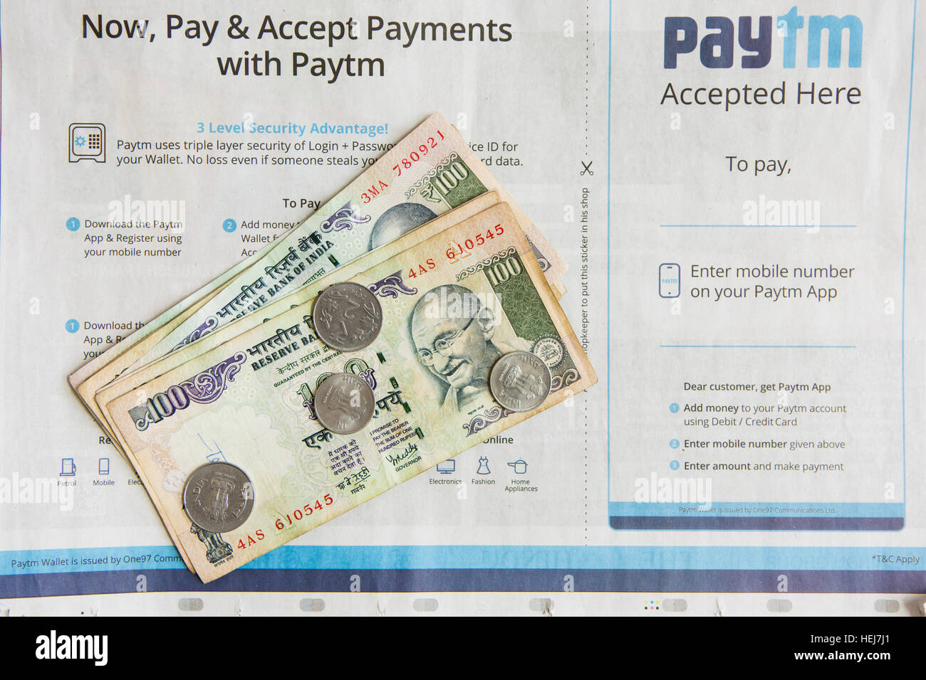 HYDERABAD, INDIA - DECEMBER 22,2016 Payments with Paytm Newspaper advertisement in India,Indian 100 rupee notes and coins Stock Photo