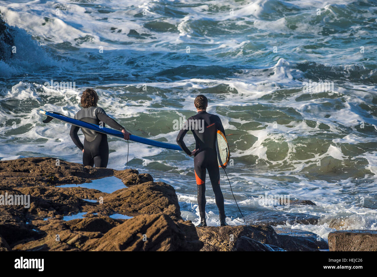 Surfers waiting for an opportunity to enter the sea at Little Fistral in Newquay, Cornwall Stock Photo