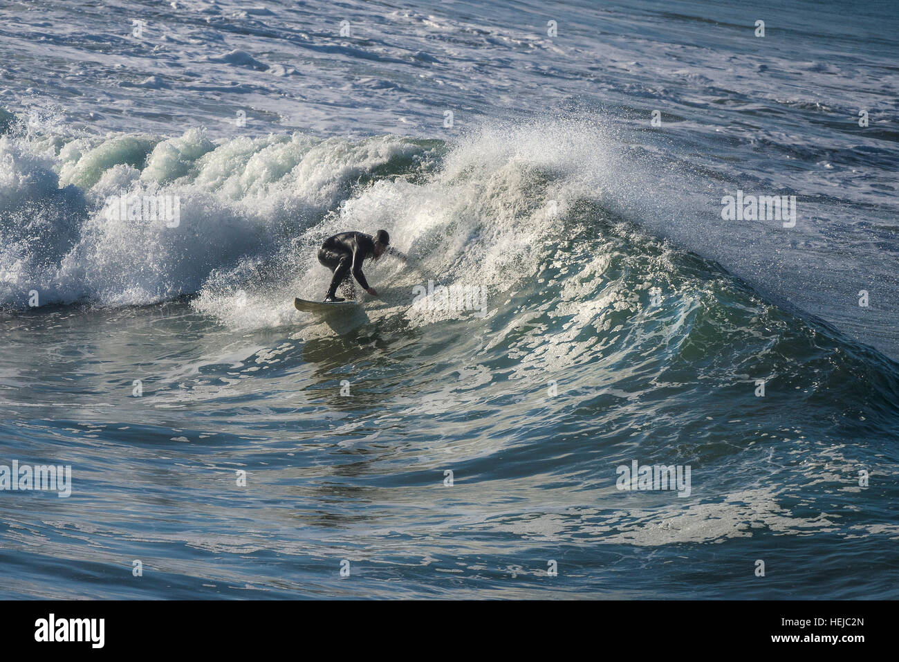 A surfer rides a big wave at Little Fistral in Newquay; Cornwall Stock Photo