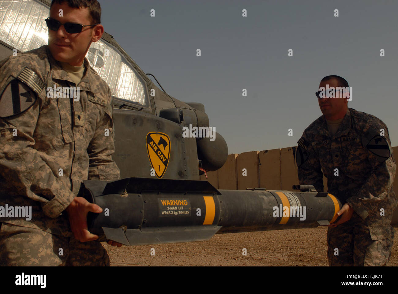 US Army 52454 CAMP TAJI, Iraq - Spc. Scott Shaver, of Austin, Texas (left)  and Spc. Bret Gibson, of Wichita, Kan., haul a Hellfire missile to load  onto the mounting bracket of
