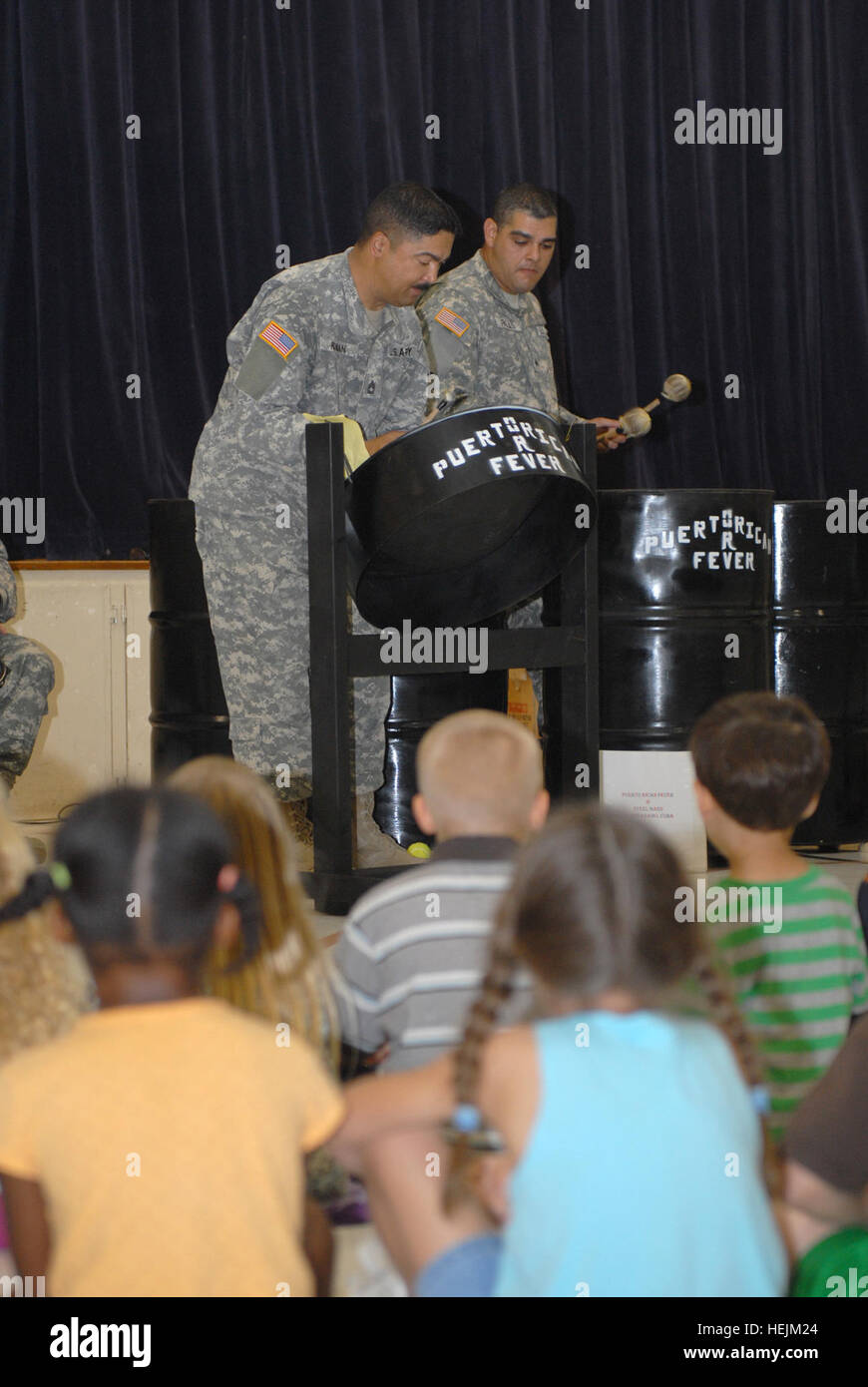GUANTANAMO BAY, Cuba – Army Sgt. 1st Class Rafael Roman and Sgt. Jose Rojas, members of Puerto Rican Fever, an all-Soldier steel drum band, perform for children at W.T. Sampson Elementary School during Hispanic Heritage Month, Oct. 6, 2009. The Soldiers, deployed to Joint Task Force Guantanamo in support of detention operations, formed the band and made the drums by hand over a period of three months and now perform regularly for audiences around JTF Guantanamo and U.S. Naval Station Guantanamo Bay during their off-duty hours. JTF Guantanamo conducts safe, humane, legal and transparent care an Stock Photo