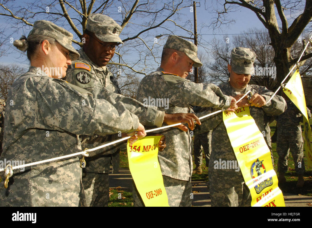 From left, 1st Lt. Angela Smith and 1st Sgt. Harry Dilworth, 354th Military Police Company commander and first sergeant, and Capt. William Geddes and Staff Sgt. Corey Beal, 304th Public Affairs Detachment commander and acting first sergeant, fasten their units? Yellow Banners to the line at Infantry Park, Dec. 4. The 354th MP Co., from St. Louis, Mo., trained at Army Support Activity, Joint Base Mcguire-Dix-Lakehurst for an Operation Iraqi Freedom mission where they will train the Iraqi police forces. The 304th PAD, from Seattle, Wash., trained at ASA JB MDL for an Operation Enduring Freedom m Stock Photo