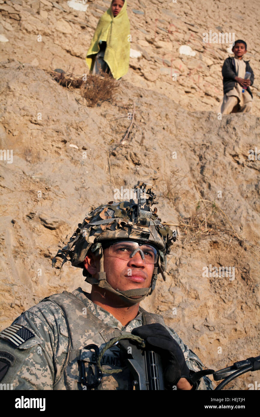 U.S. Army Capt. Albert 'Paco' Bryant, from Washington, D.C., commander of Combat Company, 1st Battalion, 32nd Infantry Regiment, 3rd Brigade Combat Team, 10th Mountain Division, sits next to a mud house during a patrol in the village of Munay in the Shigal district of Kunar province, Afghanistan on Dec. 7. OperationEnduringFreedom-SGTTeddyWadePhotographs-06 Stock Photo