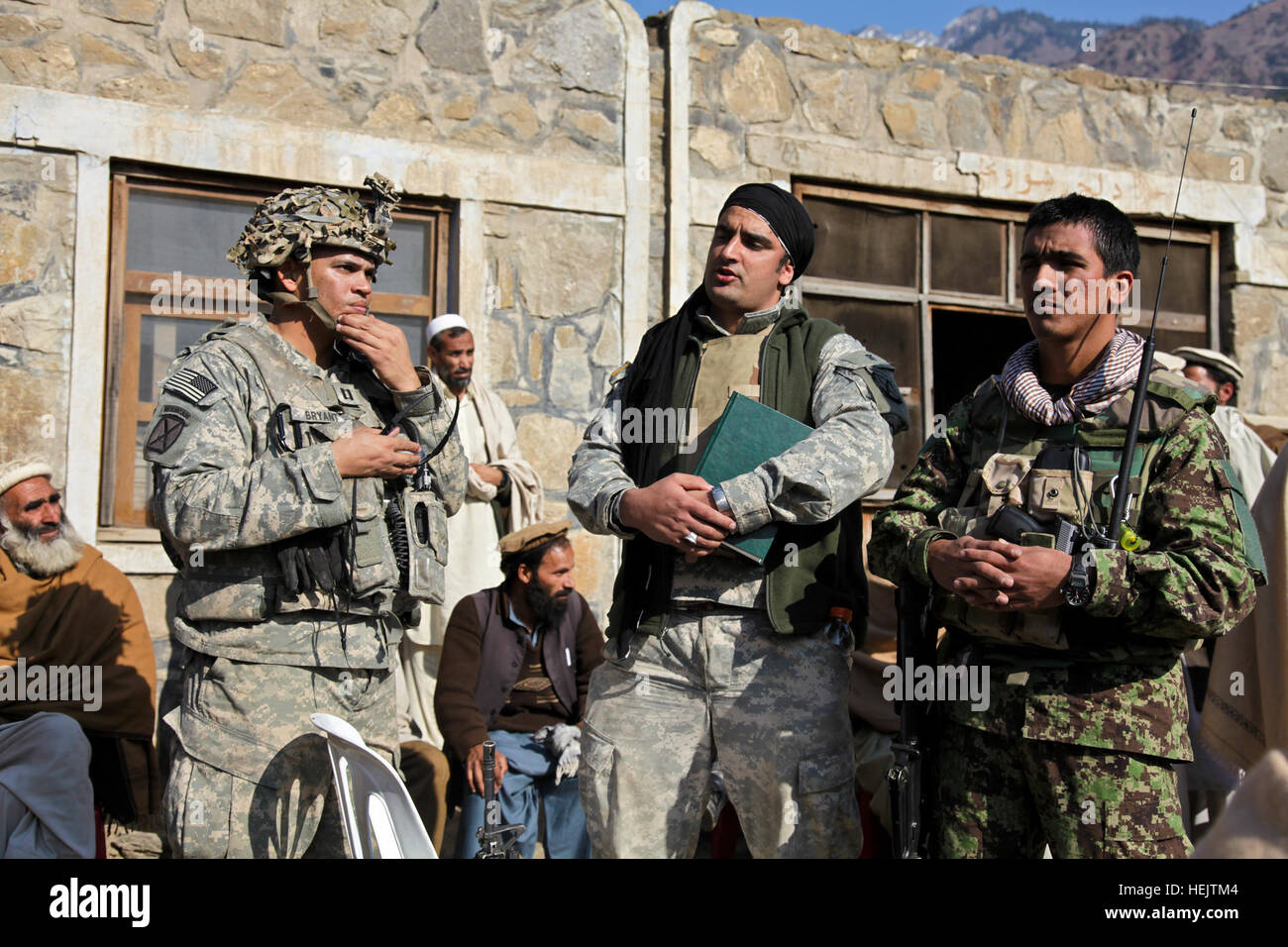 U.S. Army Capt. Albert 'Paco' Bryant, from Washington, D.C., and Afghan National Army Lt. Sowha meet with Afghan locals during a shura at the village of Lachey in the Kunar province, Afghanistan on Dec. 7. Bryant is the commander of Combat Company, 1st Battalion, 32nd Infantry Regiment, 3rd Brigade Combat Team, 10th Mountain Division. OperationEnduringFreedom-SGTTeddyWadePhotographs-07 Stock Photo