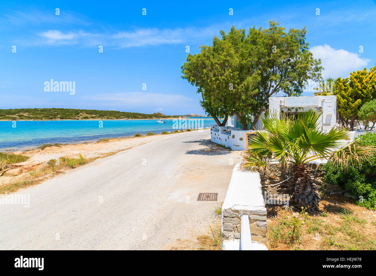 Coastal road along a beach near Naoussa village, Paros island, Greece Stock Photo