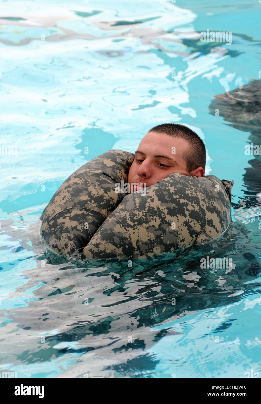 Spc. Alex Muenz, engineer, 336th Engineer Company properly uses his Army Combat Uniform trousers as a flotation device during drown proof training on Fort Hunter Liggett, Calif., Aug. 6. This technique allows the soldier to conserve energy in the water by keeping them afloat and not forcing the soldier to tread water. The engineer soldiers are at Fort Hunter Liggett for their annual training in support of Castle Installation Related Construction. Soldiers splash into safety 441730 Stock Photo