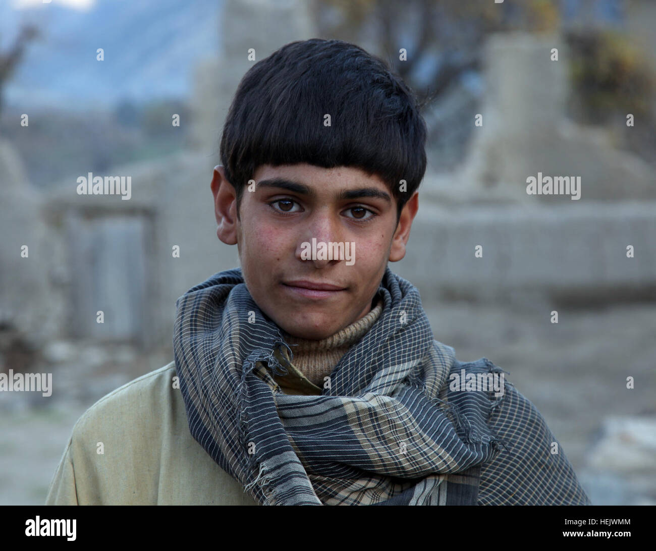 An Afghan boy looks while U.S. Army Soldiers, assigned to D Company, 2-12 Infantry Regiment, 4 Brigade Combat Team, 4 Infantry Division, speak to other village members during a patrol through the Kolak village in the Kunar province, Afghanistan, Dec. 17. Soldiers Patrol Kunar Province 233808 Stock Photo