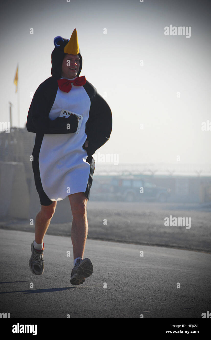 Man dressed as a penguin competes in the 4.25 mile holiday run, Forward Operating Base Salerno, Khowst Province, Afghanistan, Dec. 25. The first place winner of the race with a finishing time of 26:07 was U.S. Marine Corps Maj. Jeff O' Donnel. 4.25 Holiday Run 234845 Stock Photo