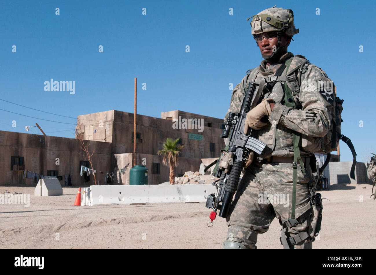 Sgt. Brandon Ford, native of Fresno, Calif., team leader, 3rd Stryker Brigade Combat Team, 2nd Infantry Division, walks the streets of Shar-E-Tiefort during a joint-dismounted patrol with the Afghan national police at the National Training Center, Aug 14. Serving in the military police platoon, also known as the 'Headhunters.' Headhunters search for their Afghan partners 444738 Stock Photo