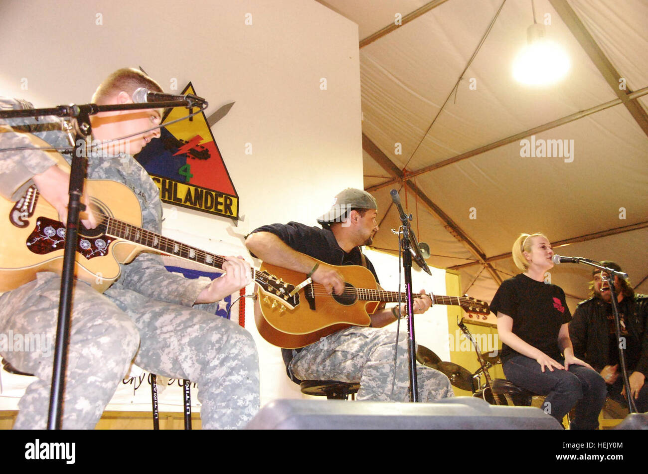 Pfc. Joshua Goad, a motor transport operator from Murfreesboro, Tenn., joins the backing band of country music recording artist Kellie Pickler, of American Idol, fame during a performance of her latest single, 'Red High Heels' at Contingency Operating Base Adder, Iraq, Jan. 17. Pickler, touring with recording artists Randy Houser and Jamey Johnson, picked Goad out of the crowd for the song. Goad is assigned to the 121st Brigade Support Battalion of 4th Brigade, 1st Armored Division 'Highlander' deployed out of Fort Bliss, Texas. The Highlander Brigade advises and assists Iraqi security forces  Stock Photo