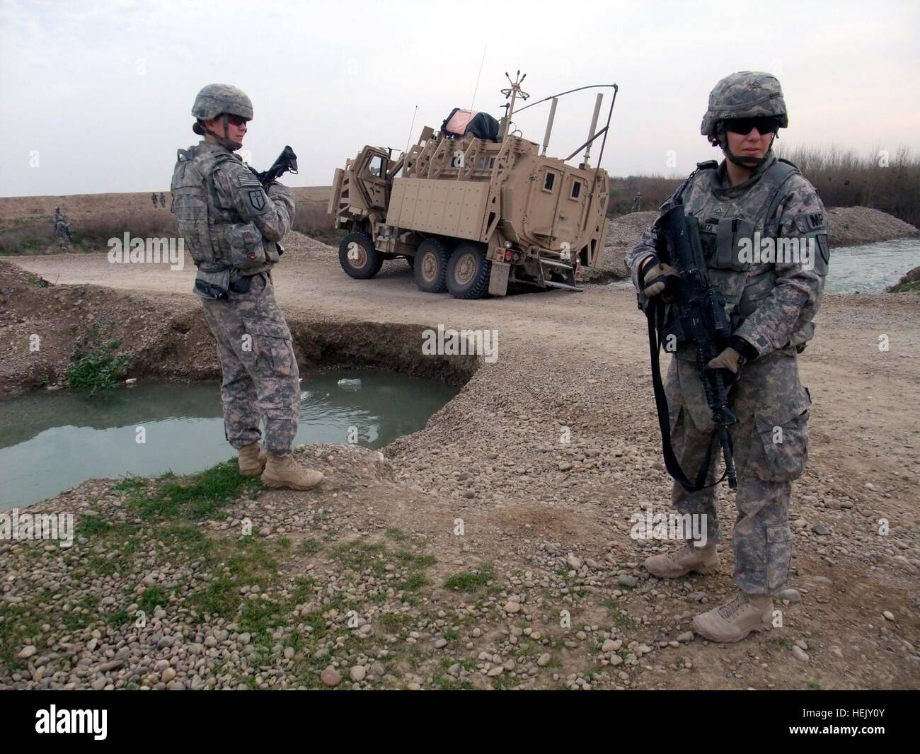 Sgt. Amber K. Kiper, a truck commander from Arcadia, Mich., and Pfc. Meghan L. Granata, a gunner from Pioneertown, Calif., pull security in Ninewa province while awaiting Q-West's quick reaction force for vehicle recovery, Jan. 18. Both serve with 3rd Platoon, 204th Military Police Company, 519th MP Battalion, headquartered in Fort Polk, La. One of the platoon's gun trucks became mired in a sinkhole during a routine patrol, requiring the Q-West recovery QRF - manned by C Company, 2nd Battalion, 198th Combined Arms, 155th Brigade Combat Team, out of Oxford and Indianola, Miss. - to extract and  Stock Photo