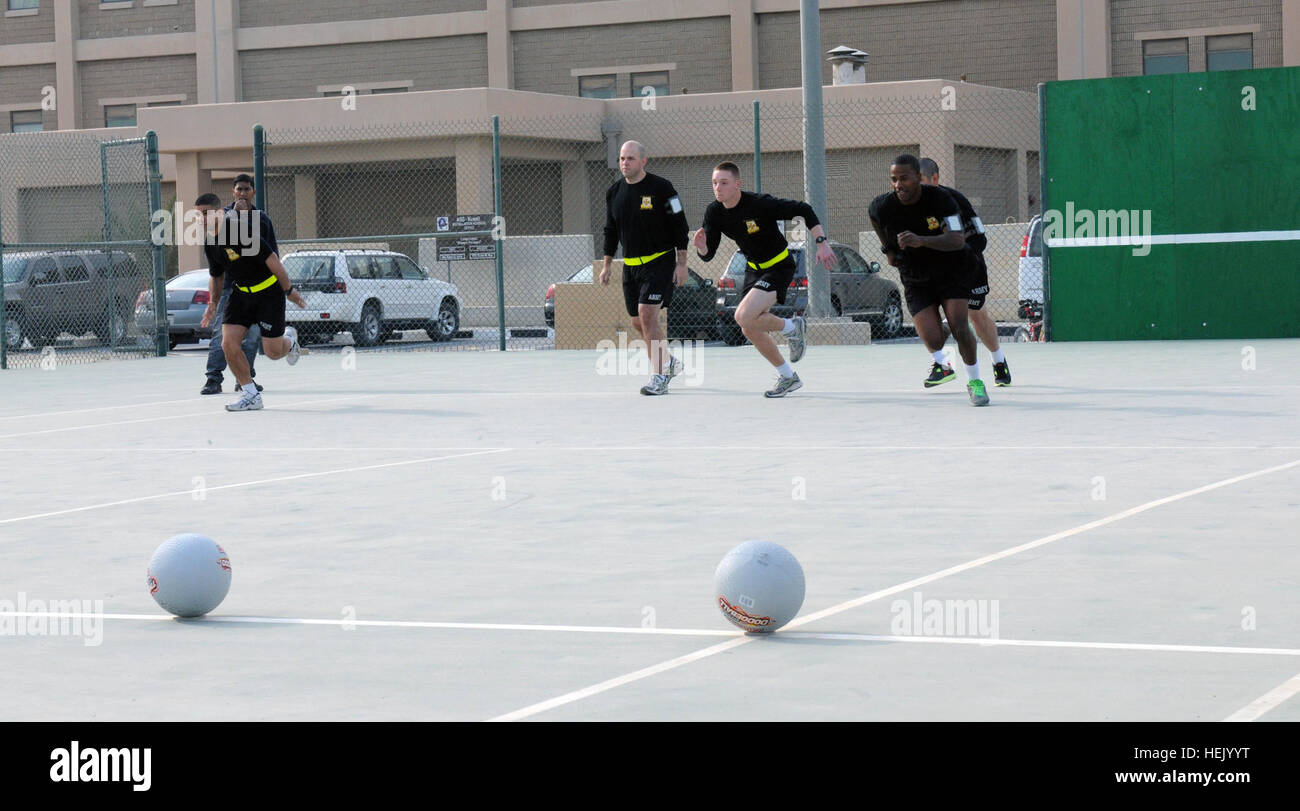Soldiers from the 9th Financial Management Company take off to retrieve dodge balls for their team during the Warrior Wellness Expo, Dec. 31. Besides dodge ball, teams competed in a bevy of other events, including an egg toss, dizzy bat run and tug-o-war. Other than the unit sports events, 3rd Medical Command (Deployment Service) offered approximately two dozen information booths for service members and civilians to learn about the different services offered here. Third Army is keeping its force ready tonight by offering events focused on mental and physical health. Third Army holds Warrior We Stock Photo
