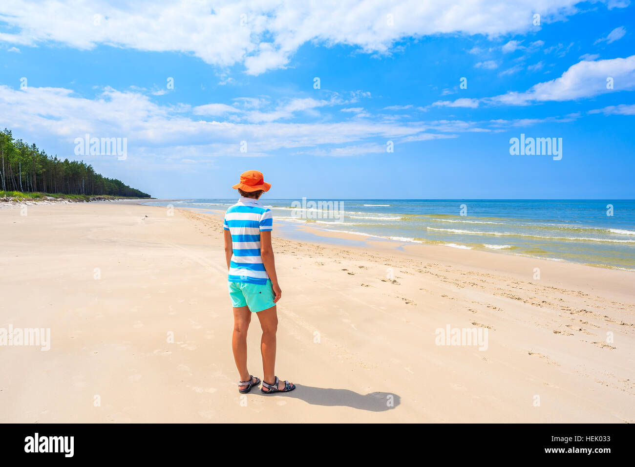 Young woman tourist standing near grass sand dune on Debki beach, Baltic Sea, Poland Stock Photo