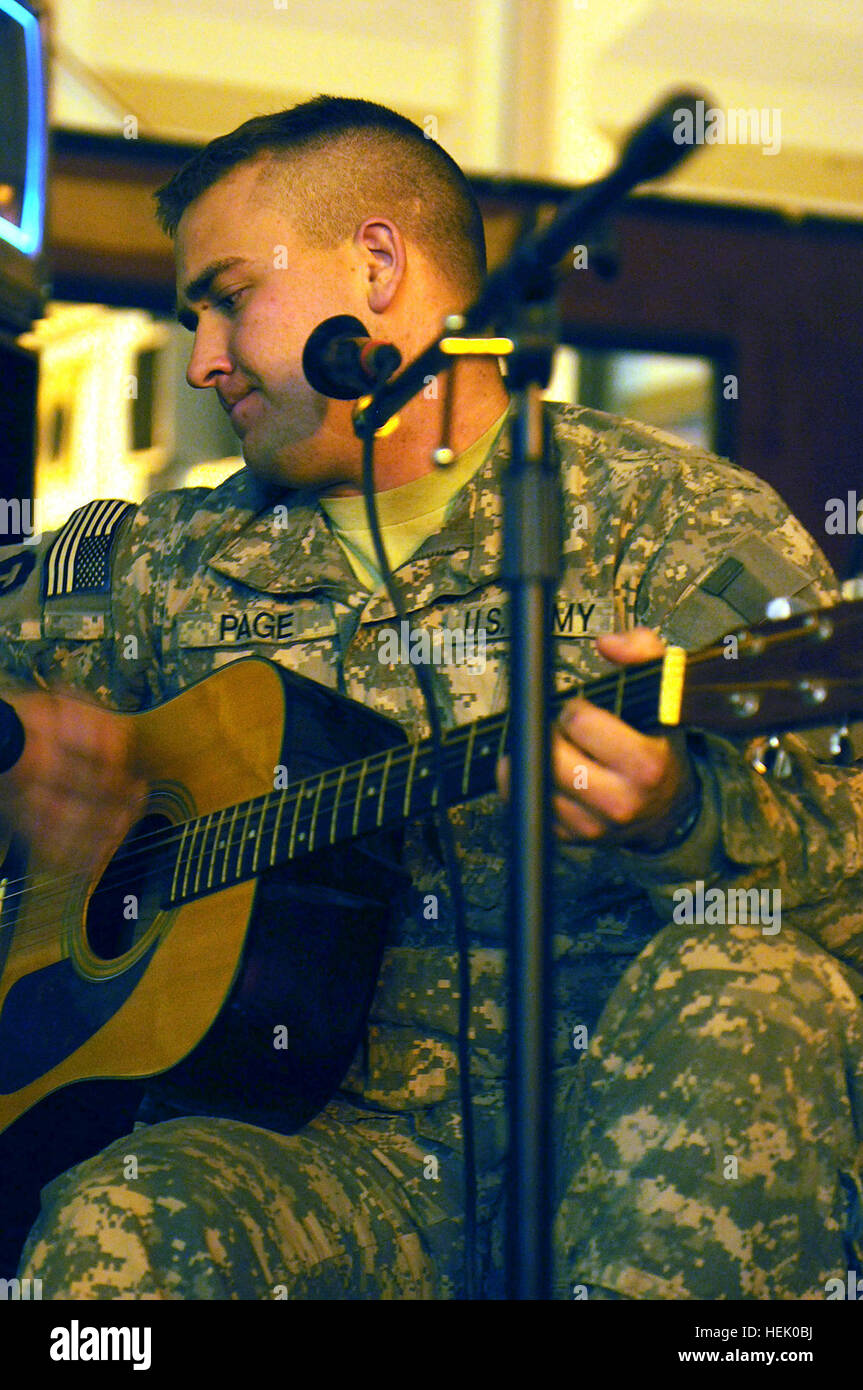 Cpl. Eric Page played guitar and performed two songs that he composed for an audience for a talent competition at the Scorpion Morale Welfare and Recreational center on Camp Liberty Feb. 19. Page, a Victoria, Texas, native and infantryman with Company B, 1-141 Infantry Battalion, 89th Military Police Brigade, received second place in the competition after wooing the crowd with his soothing voice. Now that's talent 253093 Stock Photo