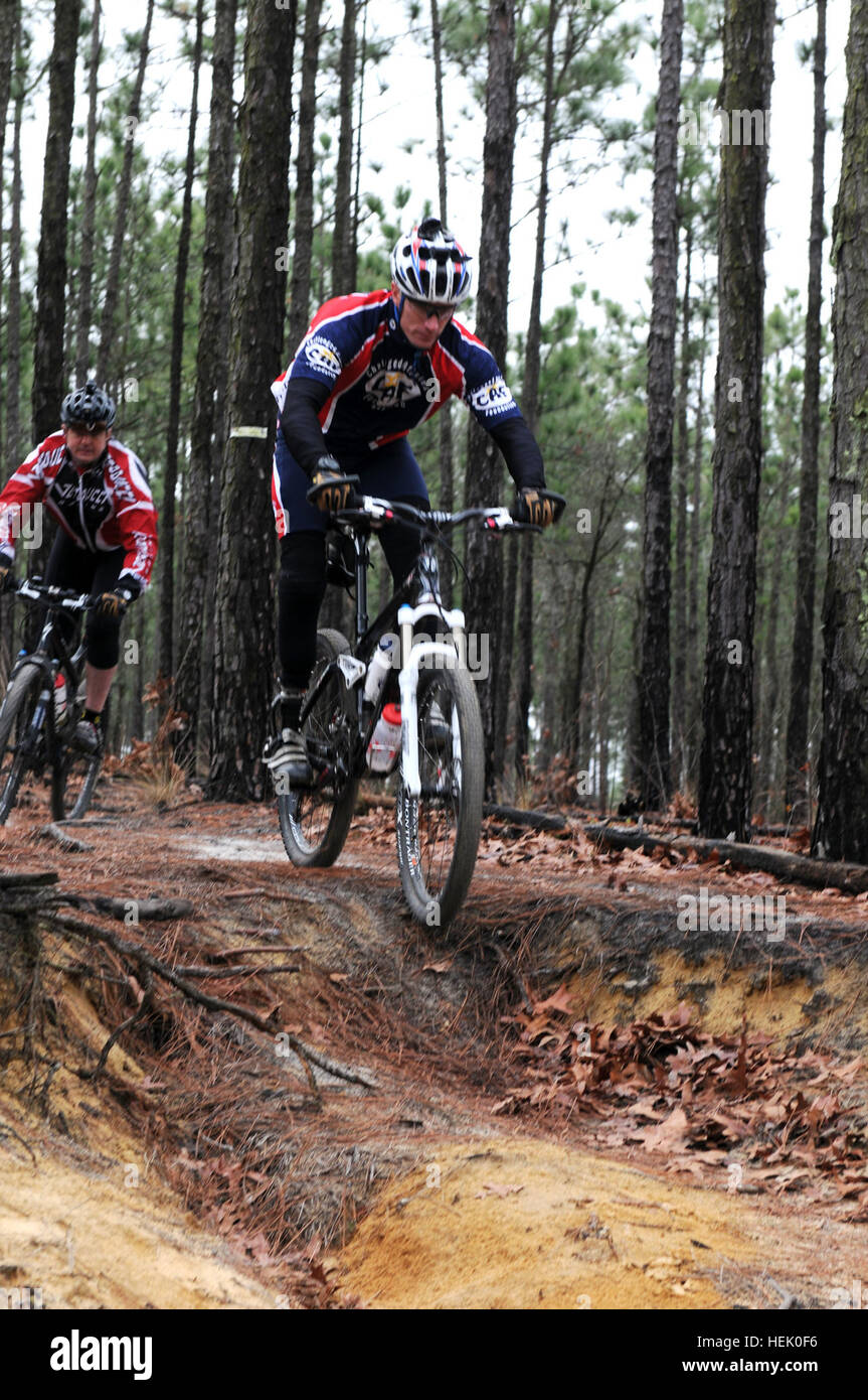 Maj. Kent Solheim, Executive Officer of the 1st Special Warfare Training Group (Airborne), and Maj. Will Cotty, Operations Officer 1st SWTG (Abn.), ride through the trails of Smith Lake at Fort Bragg, N.C.  The team has been training and riding to support charities despite Solheim’s losing his leg from battle injuries and Cotty having a knee replacement a year ago. Maj. Solheim Takes the Trail 254312 Stock Photo